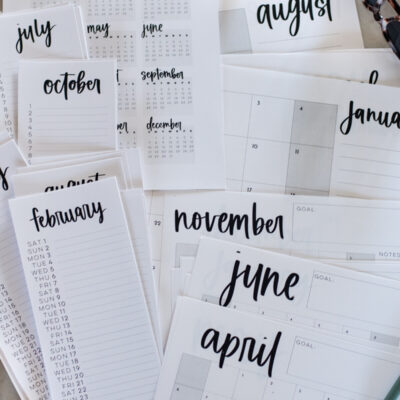 simple hand lettered collection of calendars including list calendars, perpetual calendars, monthly calendars, year at a glance calendar and large format calendars free printable for 2025, shown printed off on a marble countertop with green pen
