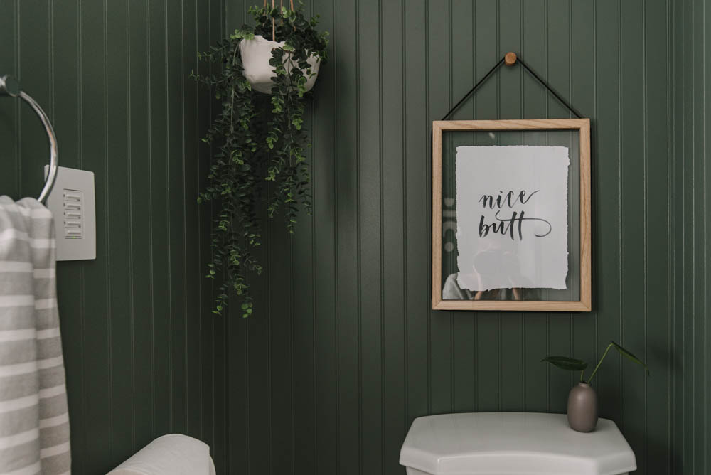DIY hanging planter out of oven bake clay for a neutral but textured bathroom accent, sign above the toilet reads 'nice butt'