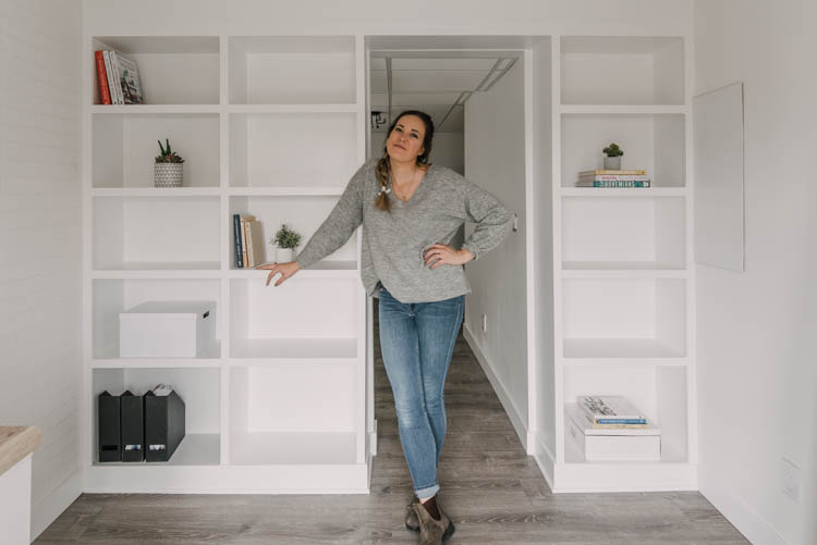 Me standing in front of my DIY built in shelving