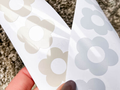 What is the best vinyl to use for my decals? a comparison- image of two sheets of flower decals, one in clay glossy permanent adhesive vinyl, one in light blue matte removable adhesive vinyl
