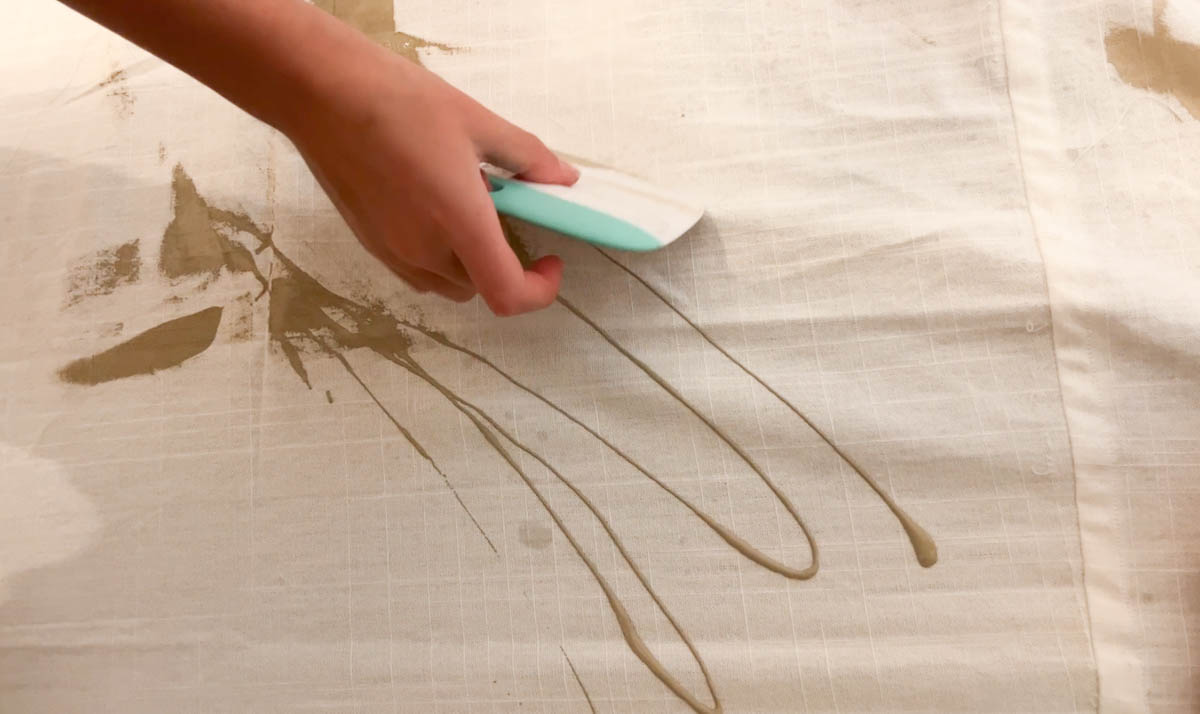 painting a wall hanging with acrylic paint and a scraper
