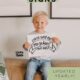 image of young boy holding a 'first day of kindergarten 2024-2025' sign text over reads 'free printable signs, updated yearly!' from lemonthistle.com