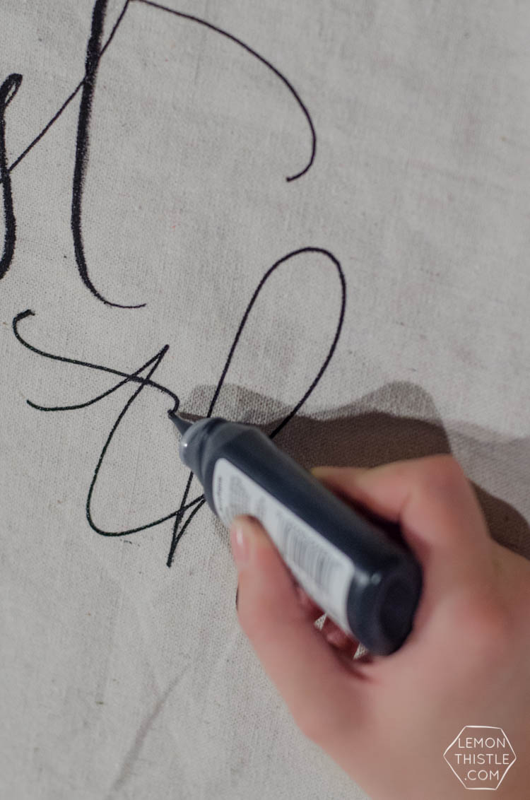 DIY giant wall hanging for simple baby shower decor using a squeeze bottle of paint