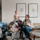 Sharing my laundry system- image of toddler on top of a pile of laundry while mom laughs