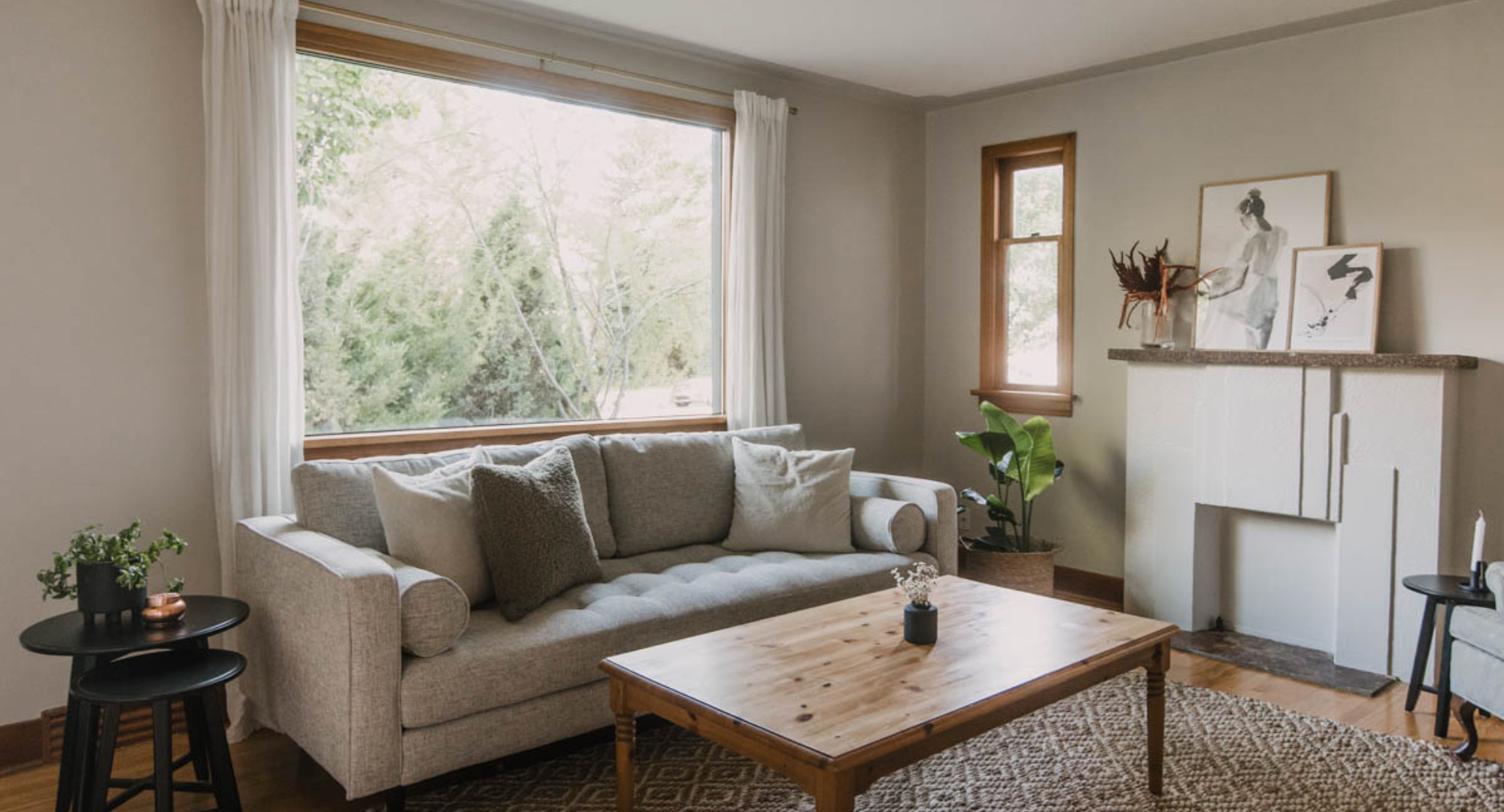 living room makeover reveal photo- grey couch in tan room with wooden coffee table and jute rug.