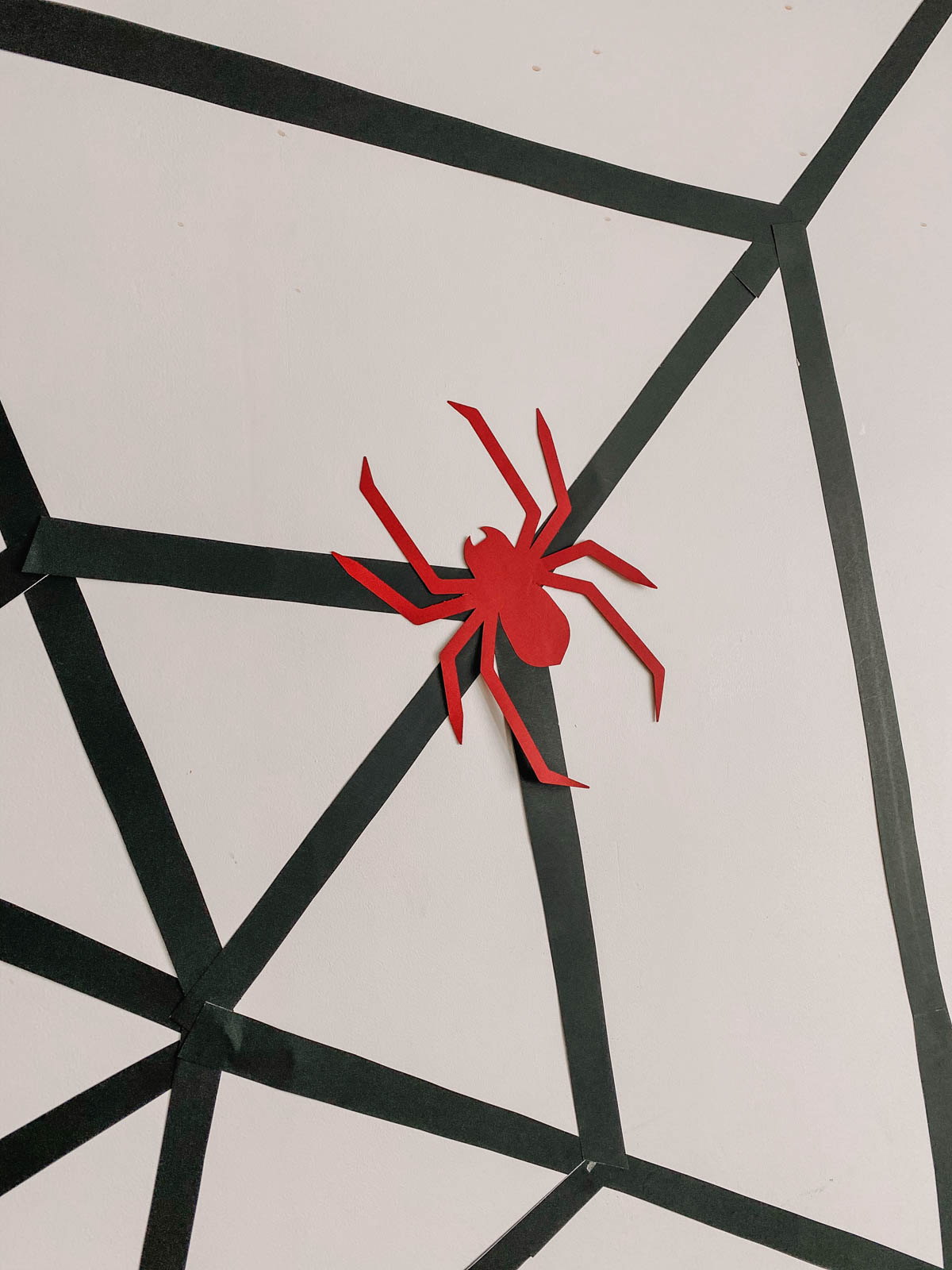 DIY Spiderman backdrop using cardstock paper spider and black poster board spiderweb