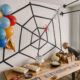 photo of a spiderman themed birthday party table with spiderman balloons, a giant spiderweb backdrop and a table full of party snacks and cake