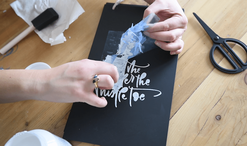 Dabbing paint on a stencil for a chalkboard effect