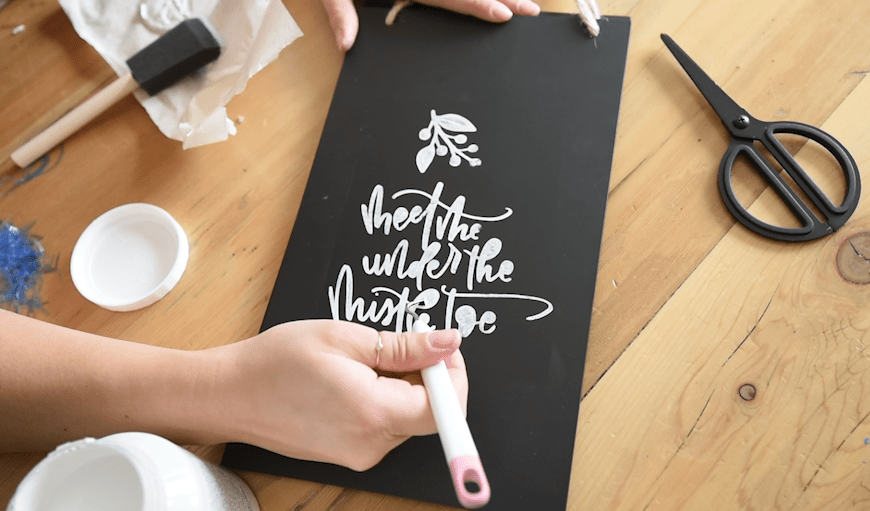 Dabbing paint on a stencil for a chalkboard effect